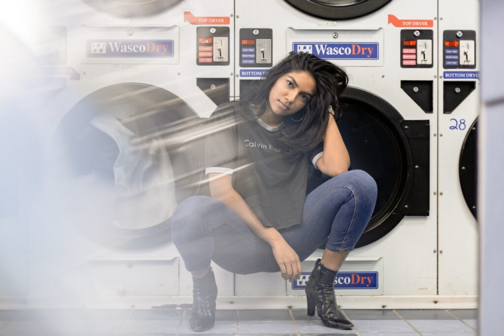 woman sitting in front of washing machine
